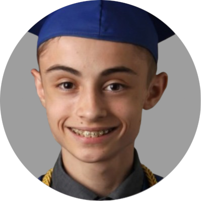 A close-up photo of a young man
											with short hair, a graduation cap,
											and a smile showing braces on
											their teeth. The individual has a
											light complexion and is wearing a
											dark graduation gown with a visible
											collar, with the background being
											a simple grey color.