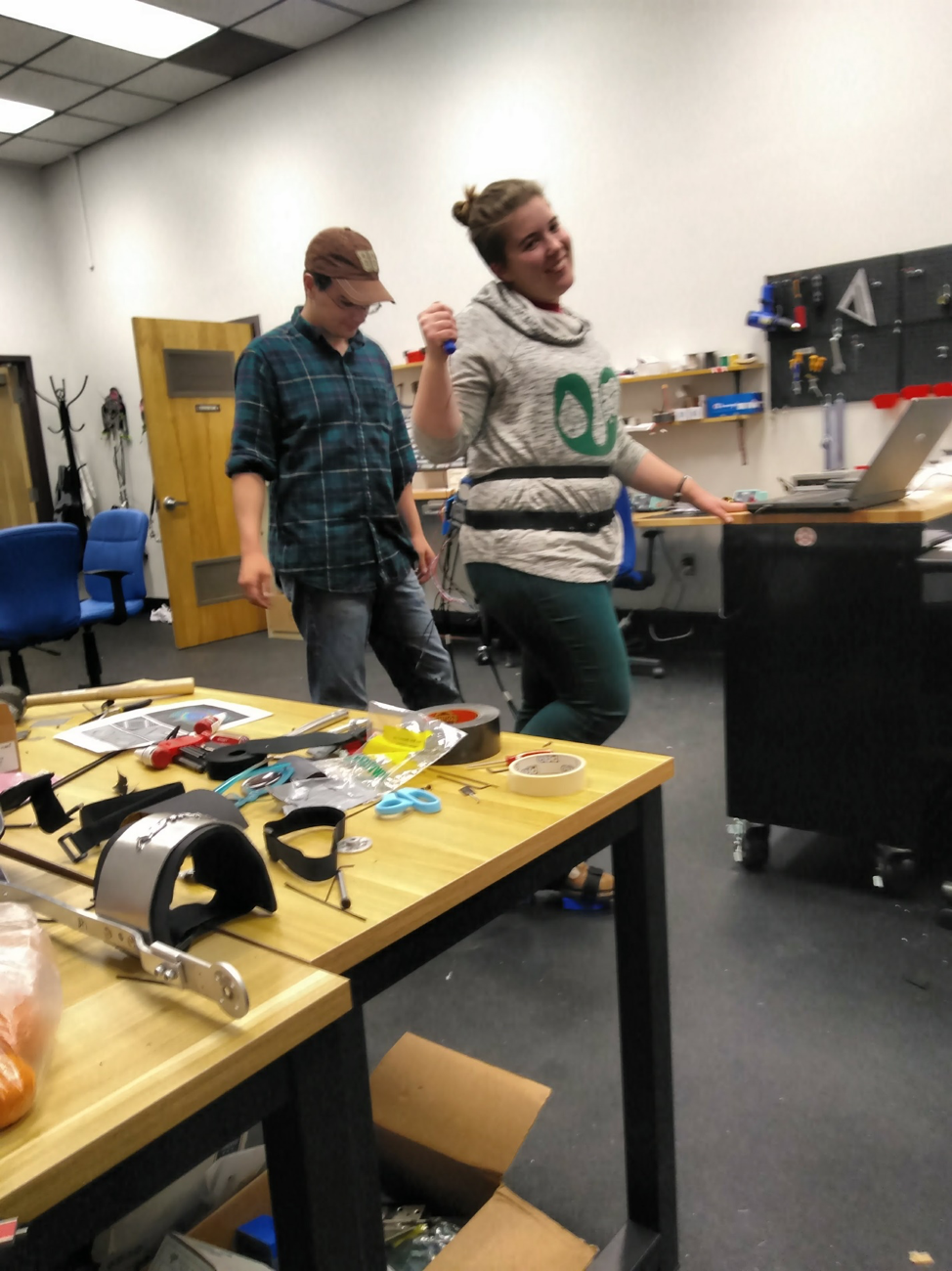 Azalea Grant having fun wearing the exoskeleton, while Robert Libby contemplates his life choices.